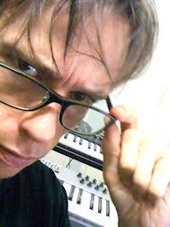 Mirko close to the camera in glasses, with a keyboard behind him